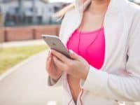 Woman in running outfit holding phone