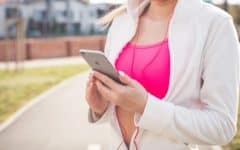 Woman in running outfit holding phone