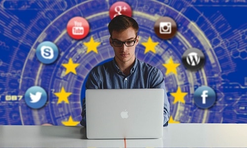 Man at computer with EU flag in background popular logos