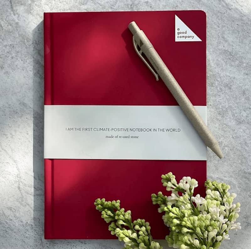 a good company maroon notebook with pen and flowers