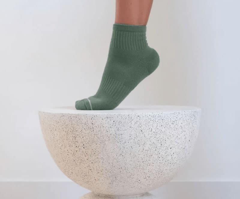 green socks stepping on stone bowl